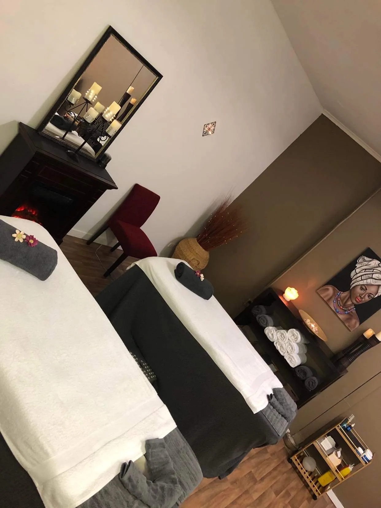 The Forever Young Werribee massage treatment room — twin dressed beds, framed art, candles and warm timber