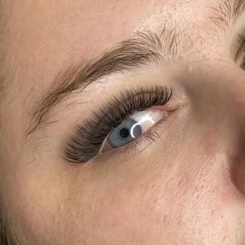 Close-up of a lash lift and extension set on a blue-eyed client